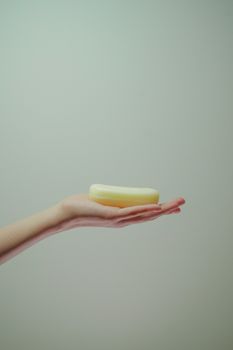 Minimalist image of a hand holding a bar of soap, highlighting hygiene and cleanliness. - Fotografer Sidoarjo