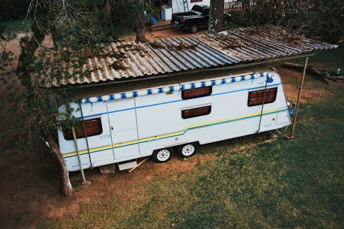 Caravan Trailer Standing under the Metal Roof in the Yard