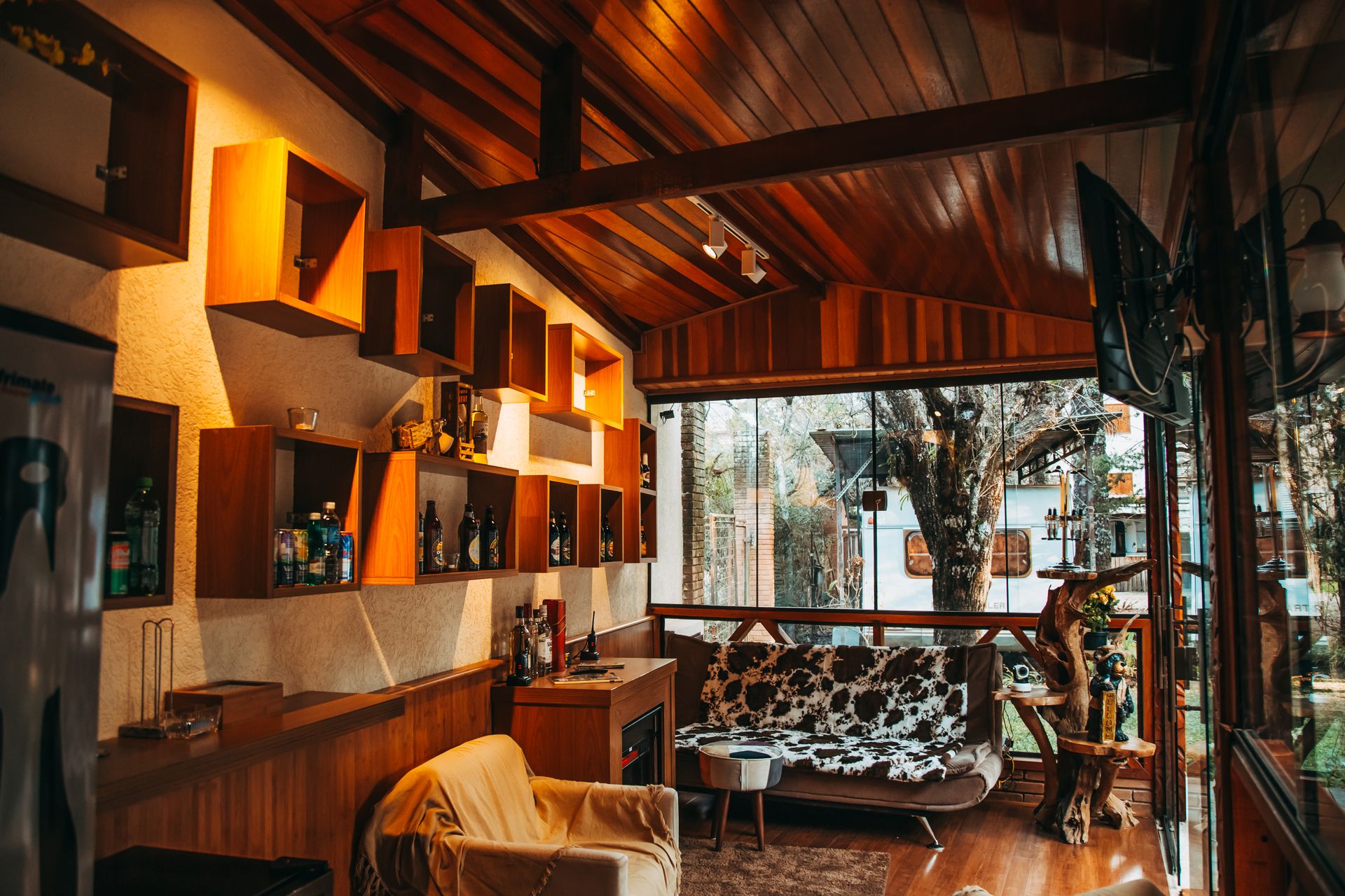 Warm and inviting cabin interior featuring modern wooden furniture and open shelving.
