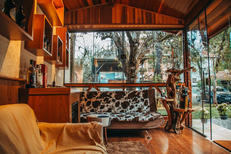 A modern living room with natural wood decor and floor-to-ceiling windows.