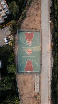 Top view of an urban basketball court nestled in a natural setting, offering a blend of sports and nature.