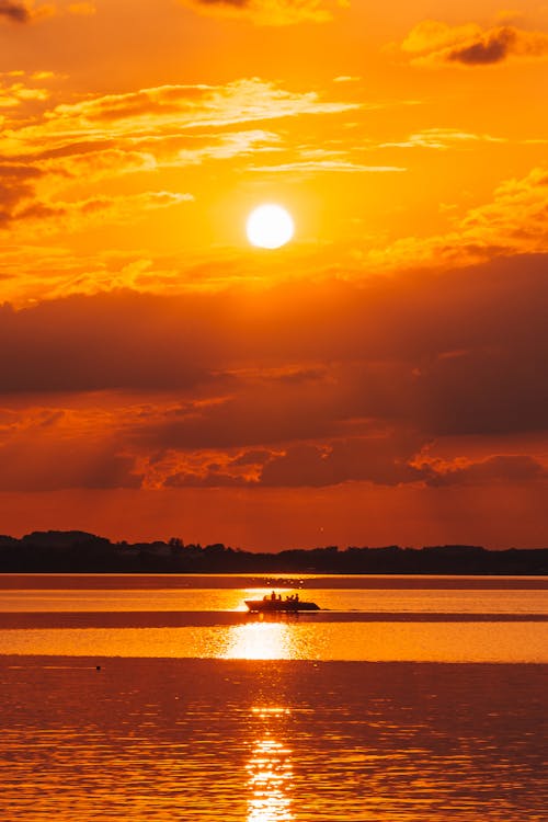 Boat on Body of Water Under the Sunset 