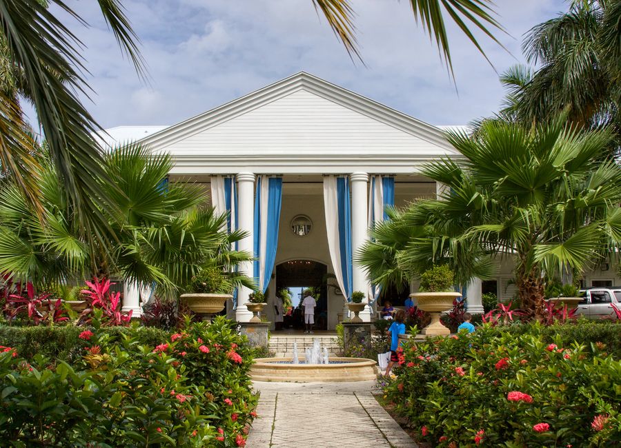 Elegant resort entrance surrounded by lush palm trees and garden, perfect for luxury travel in Sint Maarten.
