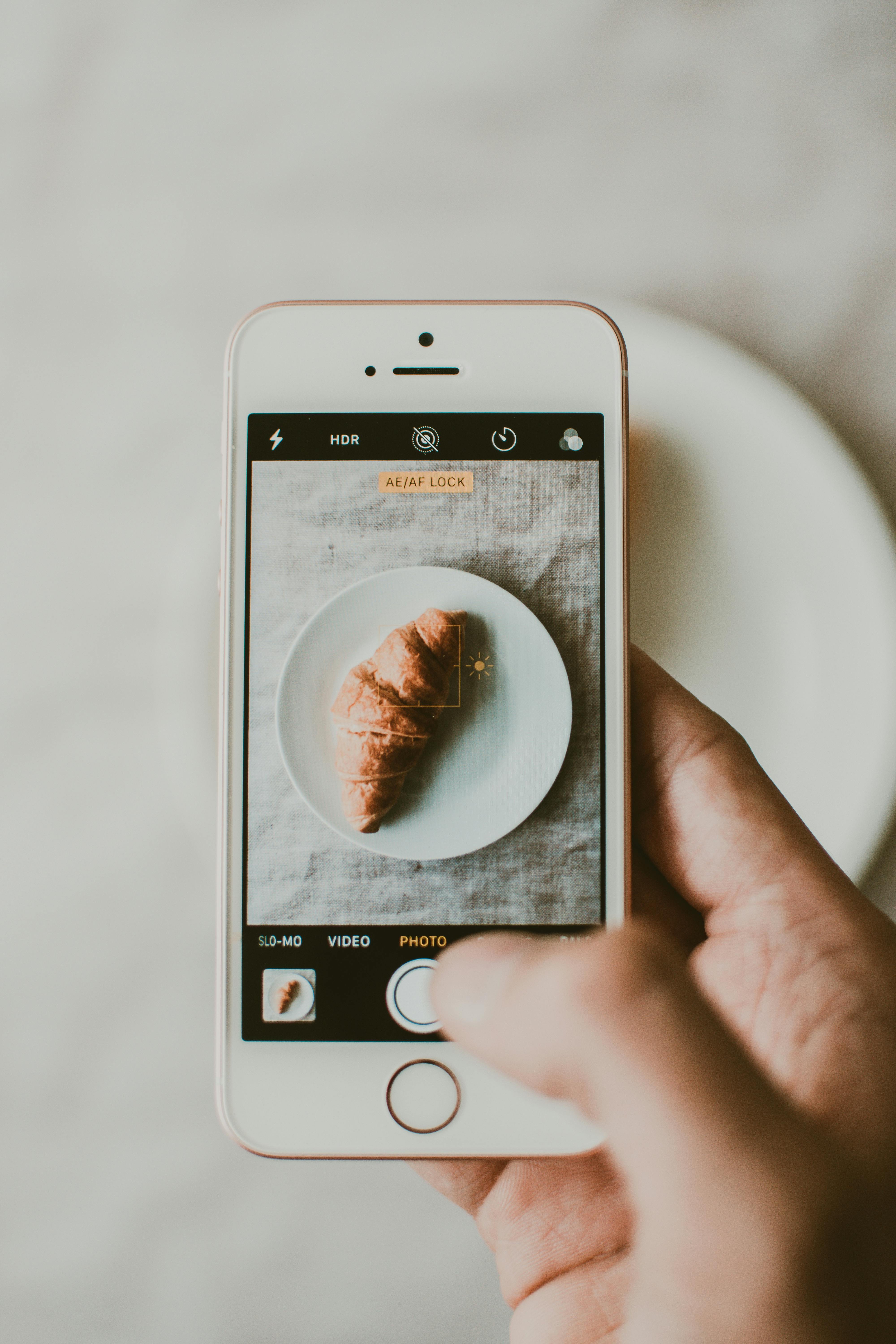 Person Taking Photo of Croissant Bread