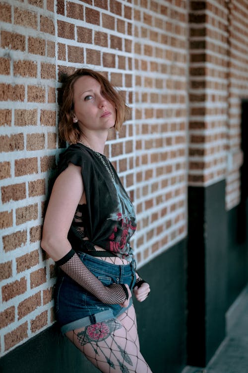 Woman Leaning on Brick Wall