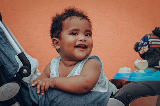 Cute Baby Sitting in a Stroller and Smiling 