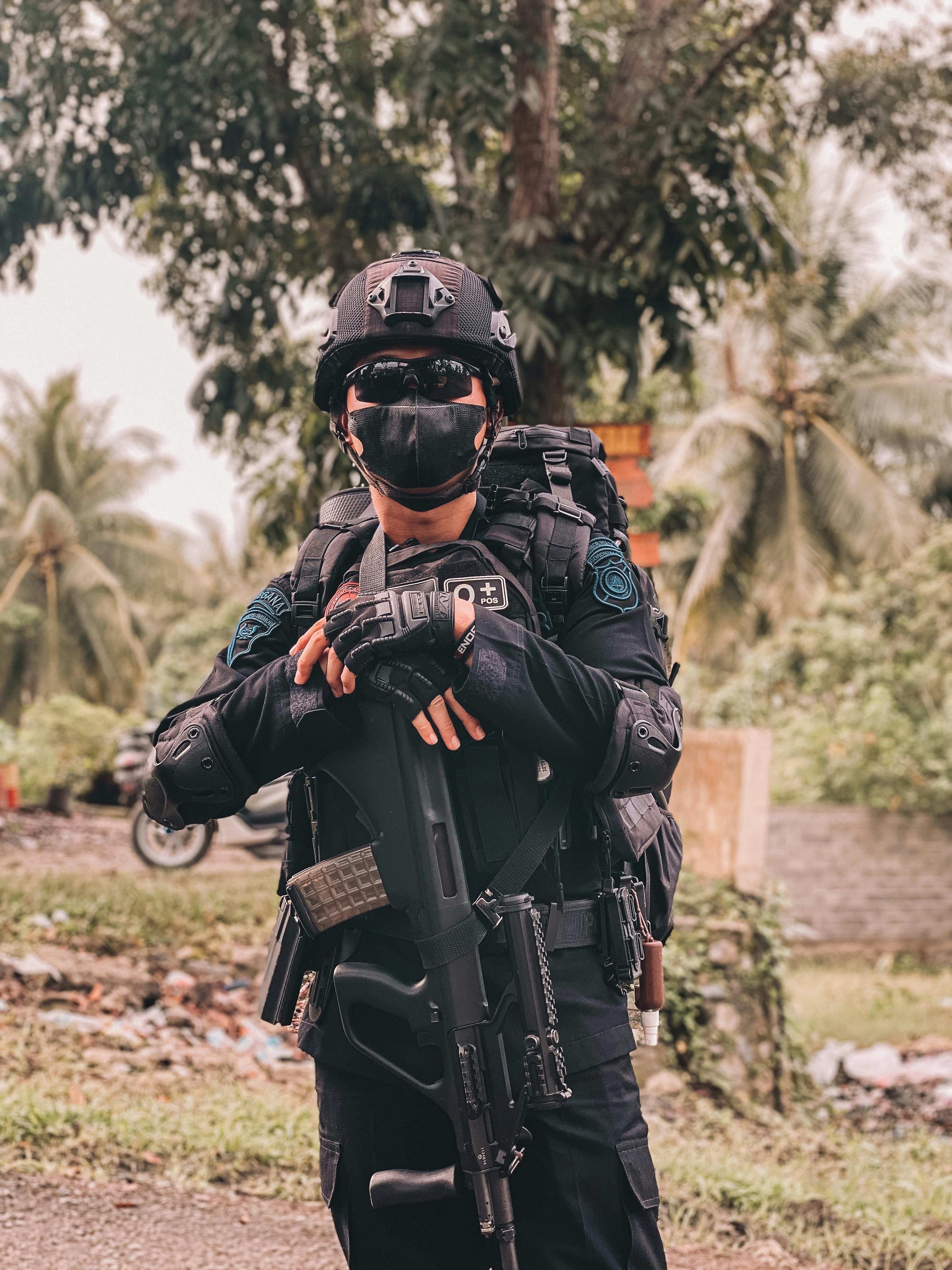 unrecognizable person wearing a military uniform carrying a gun