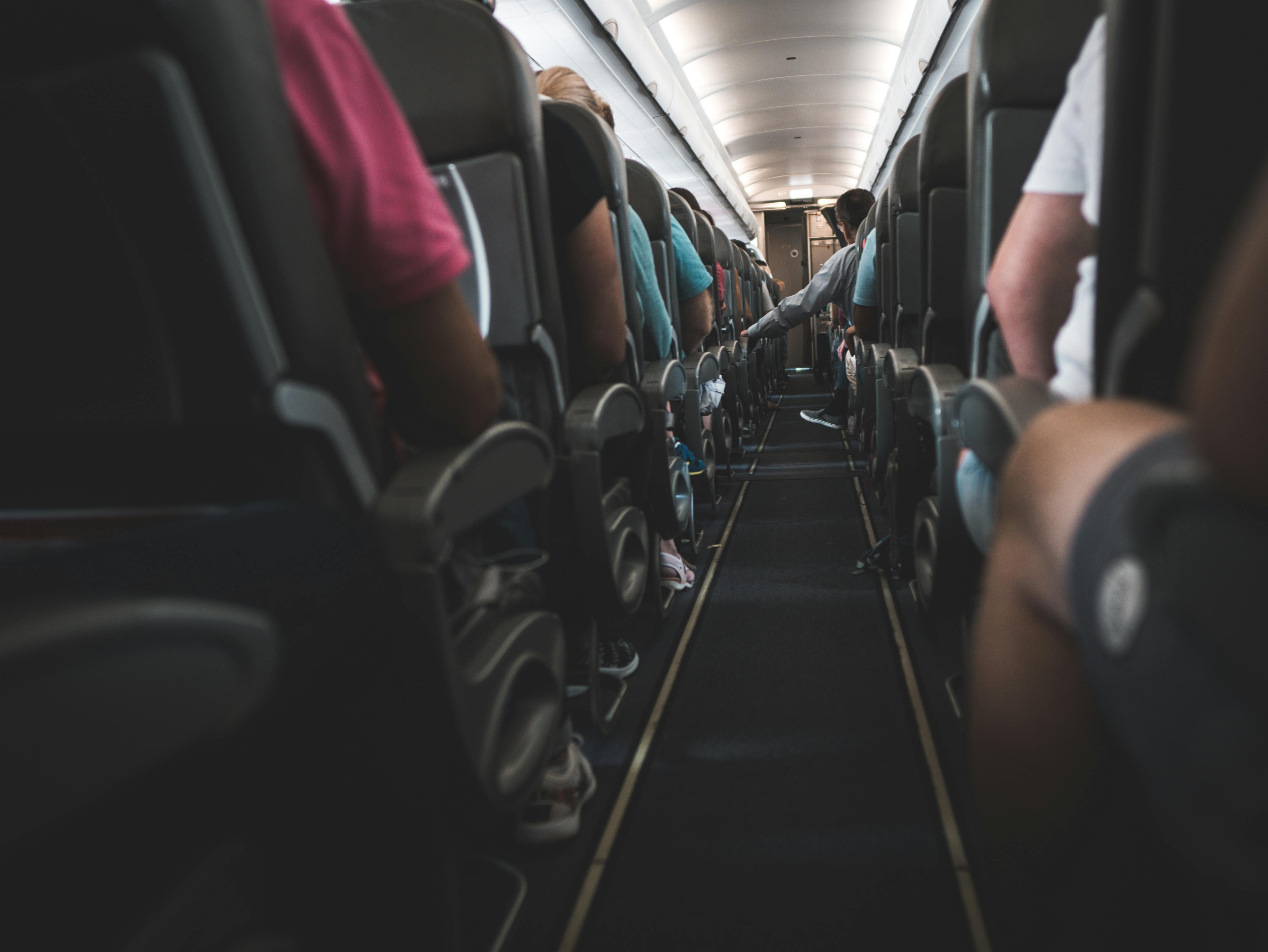 People sitting on plane chairs | Photo: Pexels