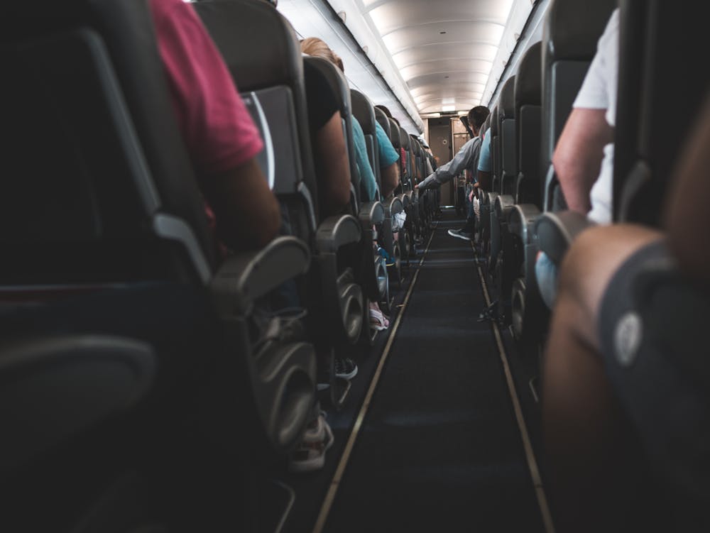 People sitting on plane chairs. | Photo: Pexels