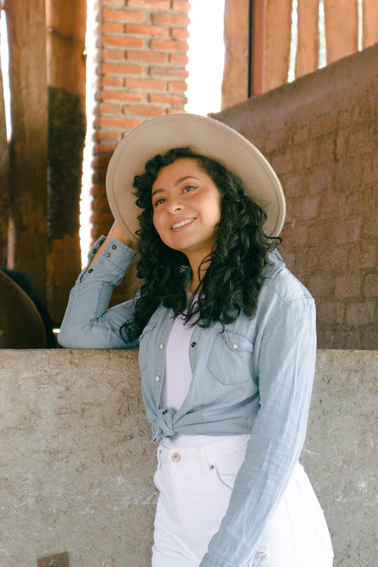 Curly Woman In Hat Posing On Farm