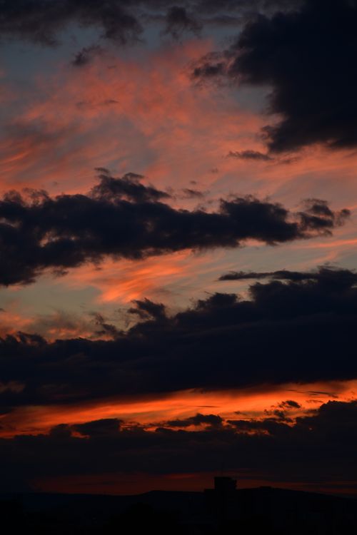 Free A vivid and dramatic sunset sky with dark clouds over Cluj-Napoca, Romania. Stock Photo