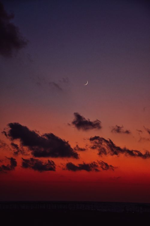 Free Capture of a breathtaking sunset over Phalasarna Beach, featuring dramatic clouds and a crescent moon. Stock Photo