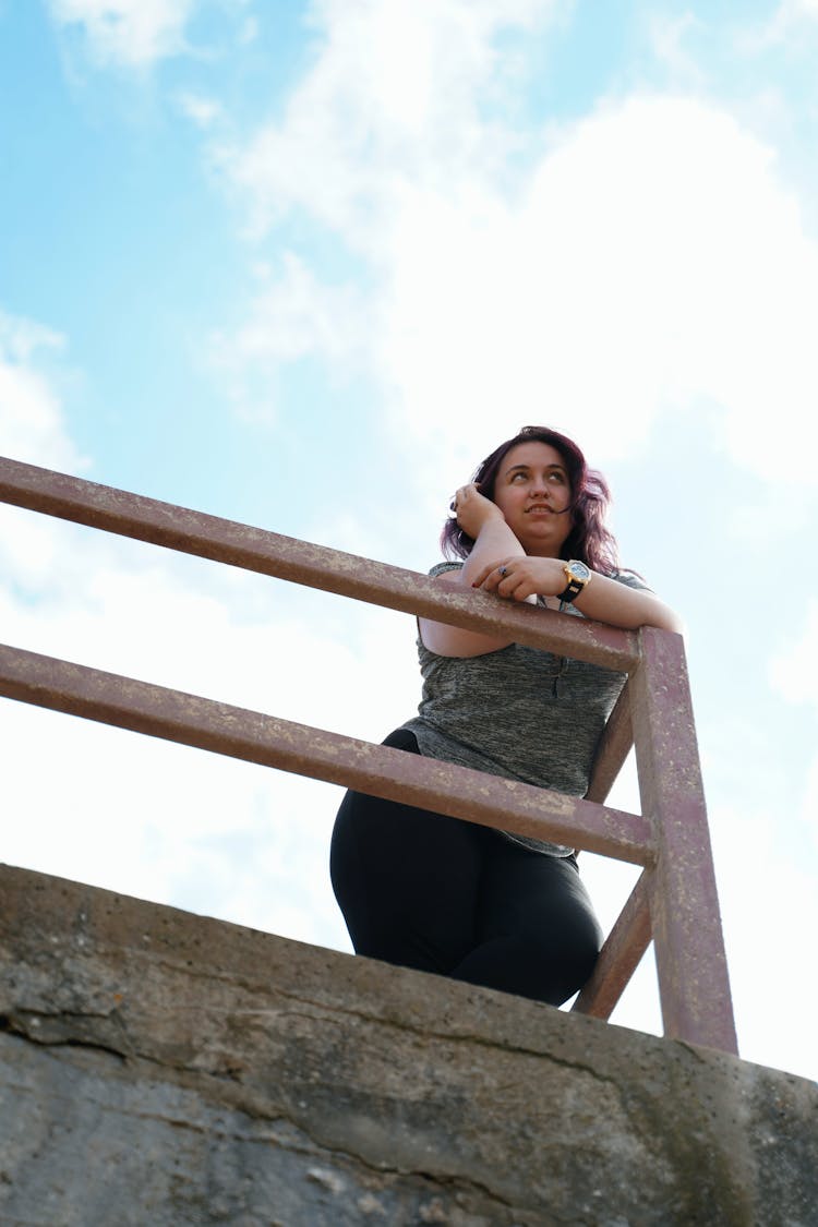 Curvy Woman Leaning On Metal Railing