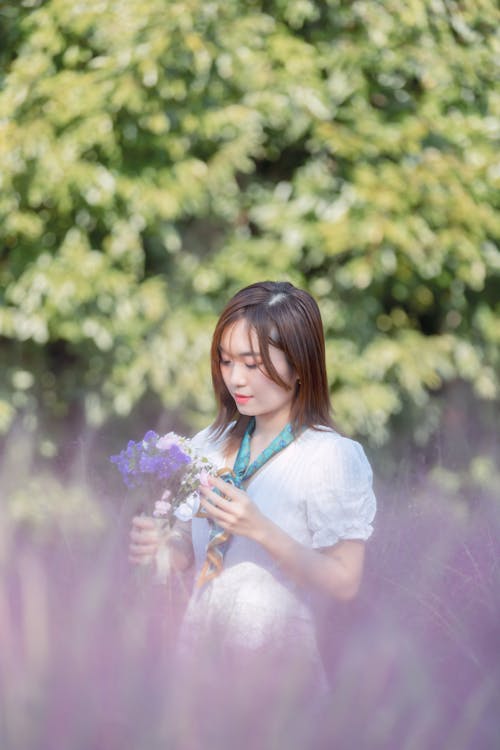 Young Woman Holding a Bouquet Outdoors in Summer 