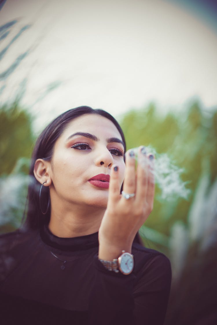 Woman Blowing Dandelion Seeds