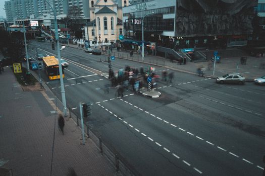 Urban life in Minsk with people crossing the street at a busy intersection.