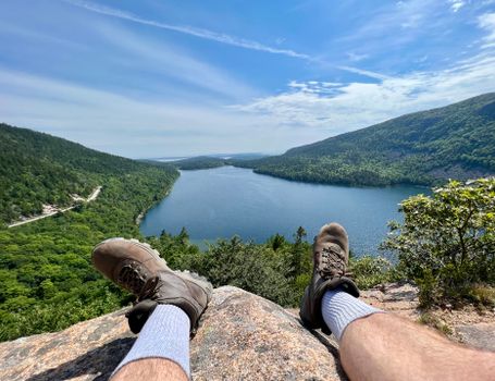 Man Sitting on a Rock with View of the Jordan Pond in Acadia National Park, Maine, USA
