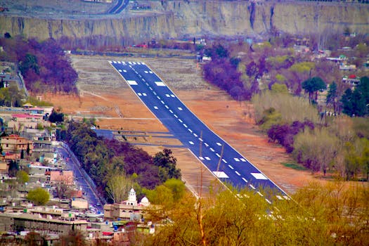 Beautiful aerial shot of an airport runway surrounded by colorful autumn foliage.