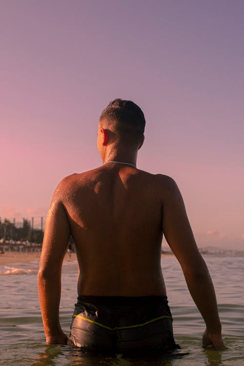 Topless Man Standing on the Beach