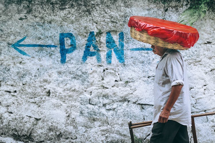 A Man Carrying A Load Over His Head