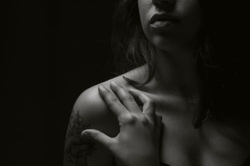 Monochrome Photo of a Woman's Hand on Her Shoulder