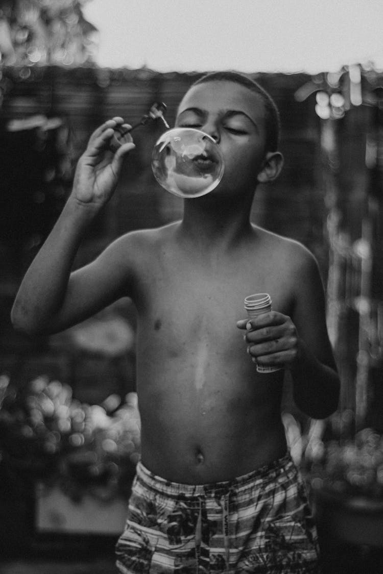 Boy Blowing Soap Bubbles Outdoors