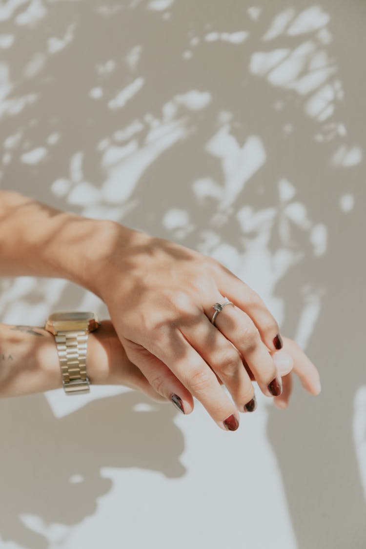 Woman With Manicured Nails Wearing A Ring And A Gold Watch