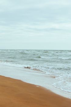Serene beach view in Baku, Azerbaijan with gentle waves and a cloudy sky.