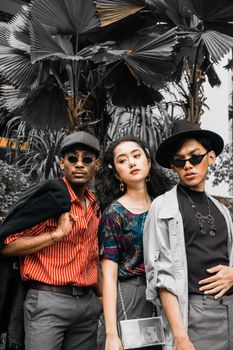 Trendy group of adults in urban fashion outdoors, showcasing bold creative style.