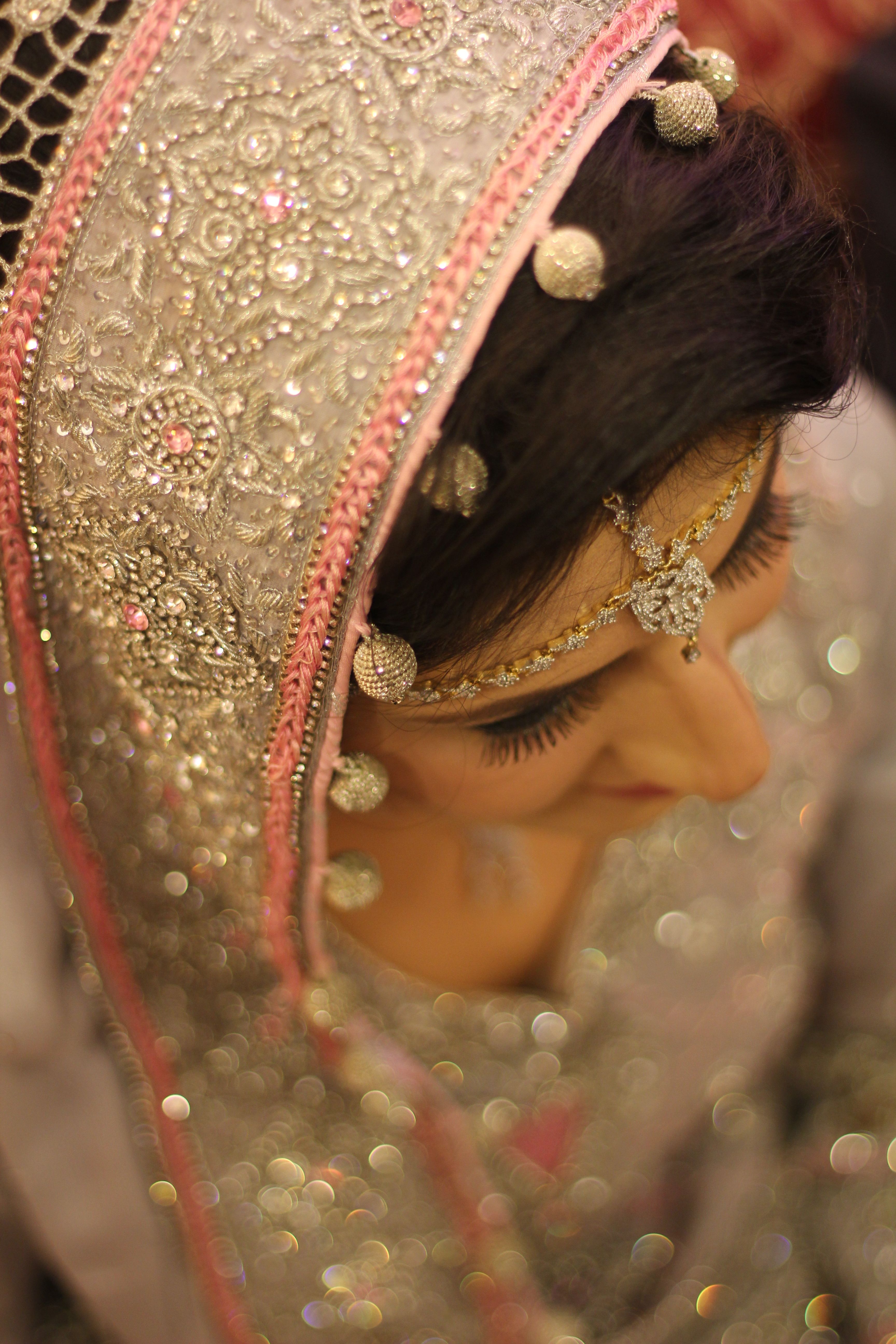 A stunning close-up of an Indian bride adorned in intricate silver embroidered attire, showcasing traditional jewelry.