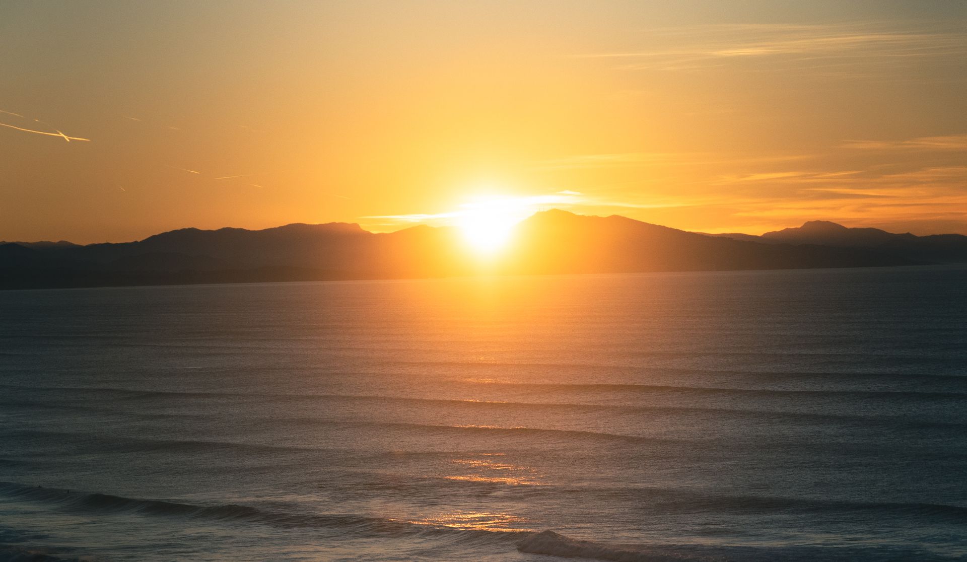 Beautiful sunset view over the ocean in Biarritz, France, with glowing orange skies and serene waves.