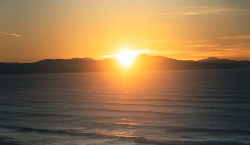 Free Beautiful sunset view over the ocean in Biarritz, France, with glowing orange skies and serene waves. Stock Photo