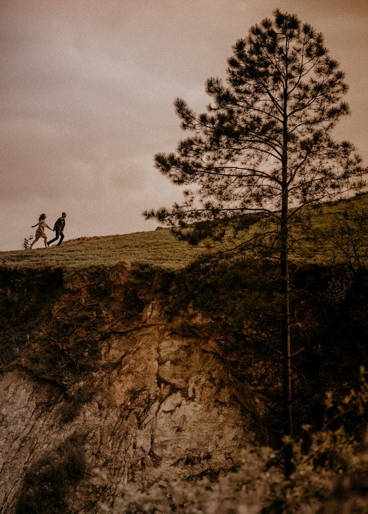 Couple Running On Hill On Horizon