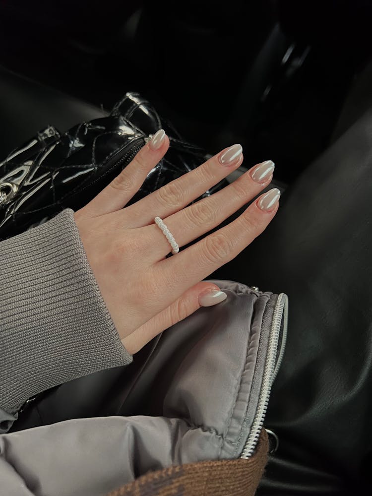 A Person With Manicured Nails Wearing A Pearl Ring