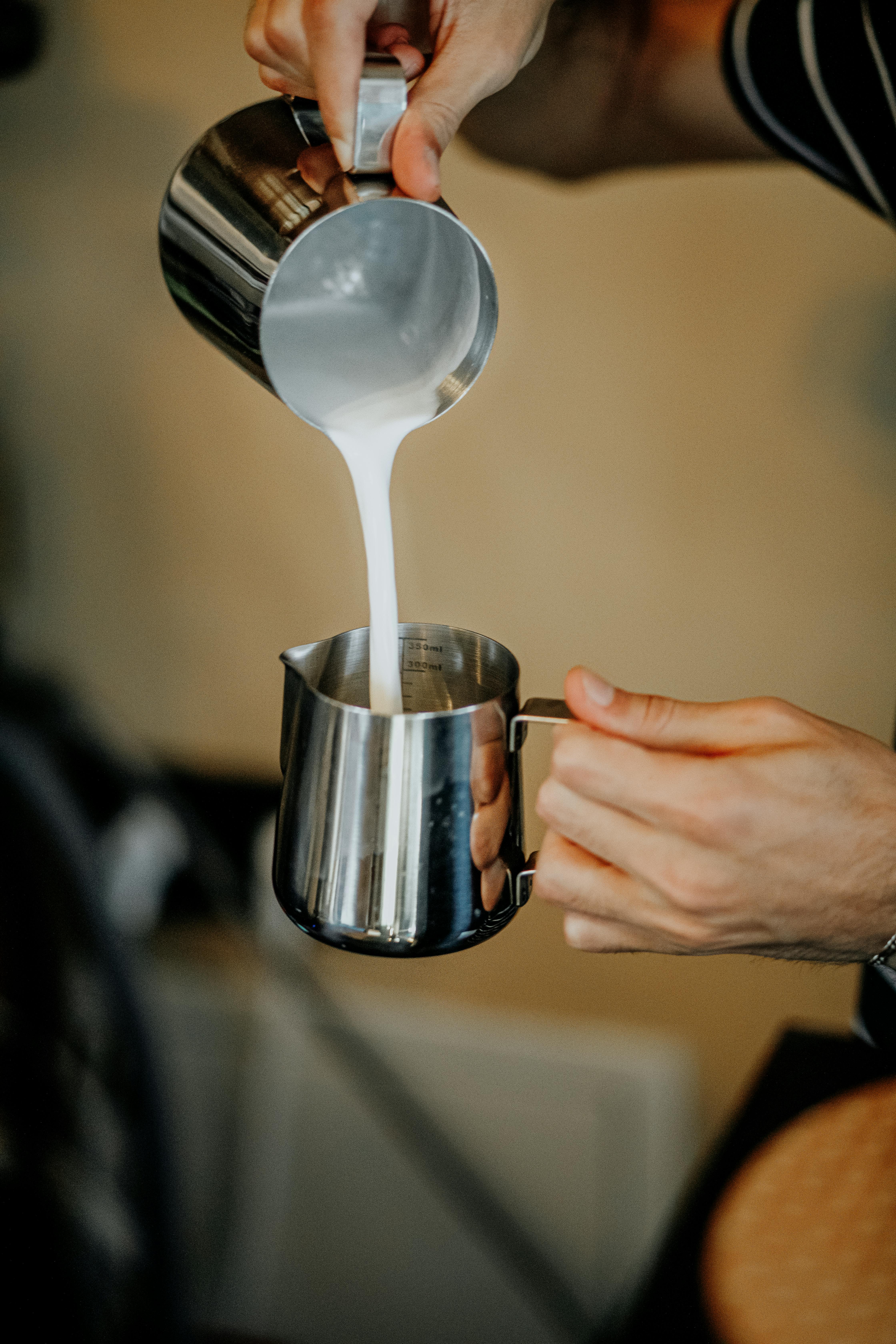 Person Pouring Milk on Frothing Pitcher · Free Stock Photo