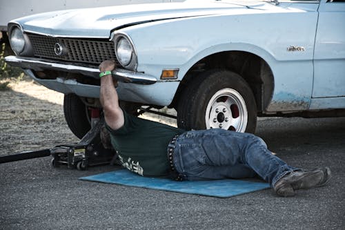 Free Man Working Under His Car Stock Photo