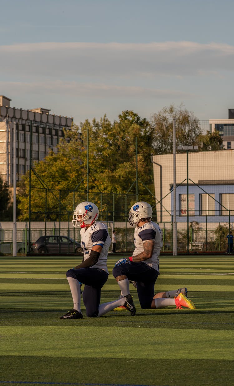 Football Players Kneeling On Field