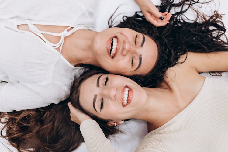 Laughing Women Lying On Back Cheek To Cheek