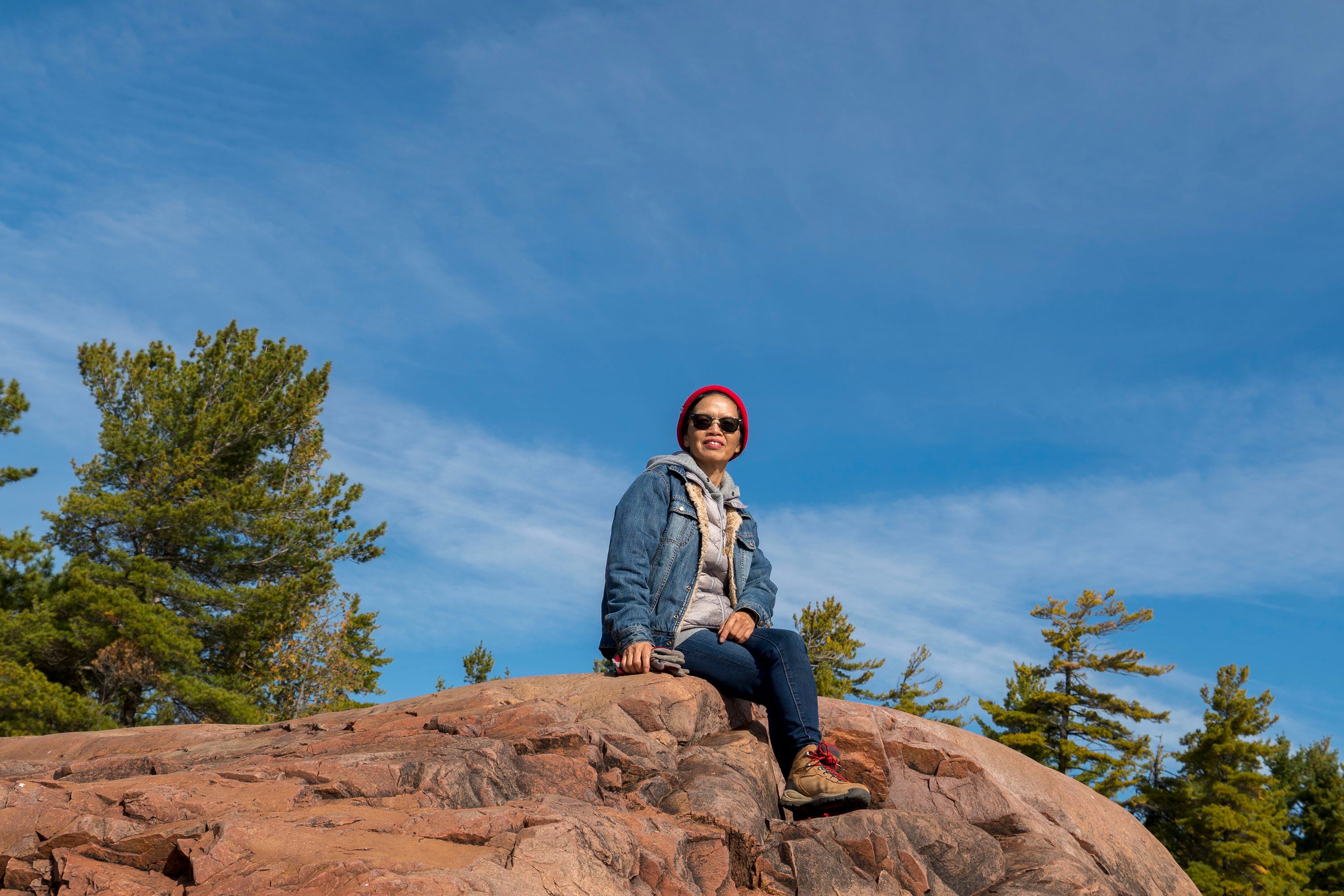 A Woman Wearing Denim Jacket Sitting on the Rock · Free Stock Photo