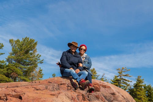 Free A Couple Sitting on Cliff Rock Stock Photo