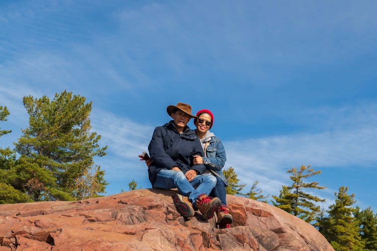 A Couple Sitting On Cliff Rock