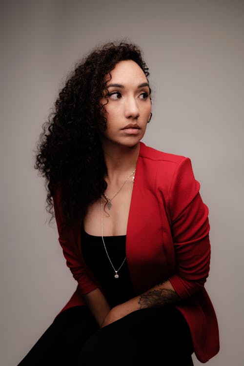 A Woman in Red Blazer Wearing Silver Necklace