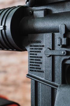 Close-up view of warning label on a firearm, highlighting safety precautions.