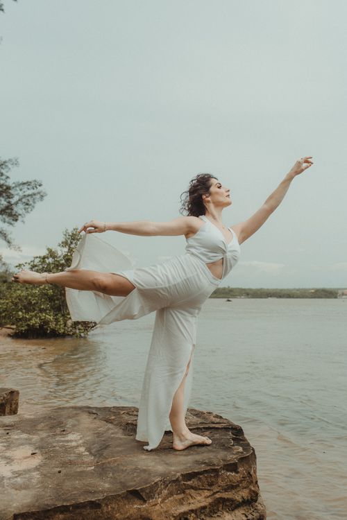 A Woman in White Pants Standing Barefooted on a Rock Formation · Free ...