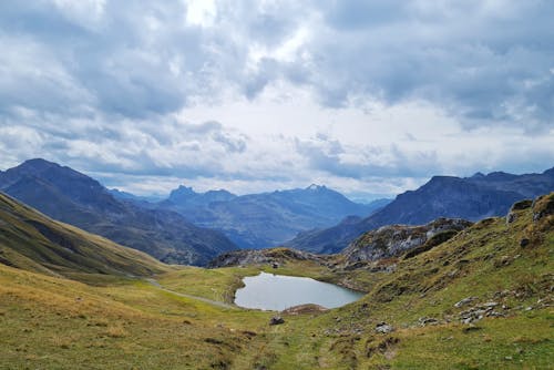 A Lake Between Mountains Under the Cloudy Sky