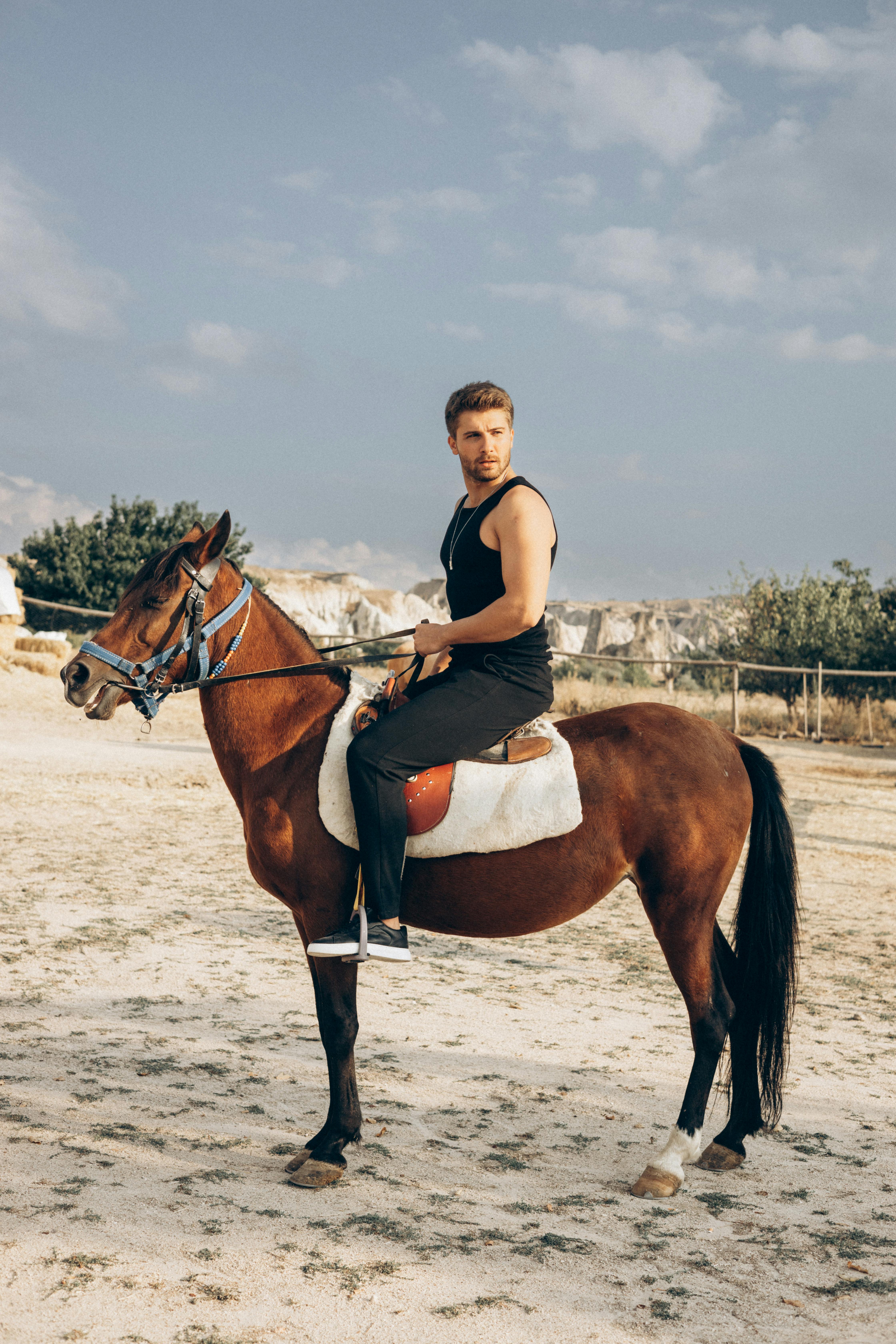 man riding a brown horse