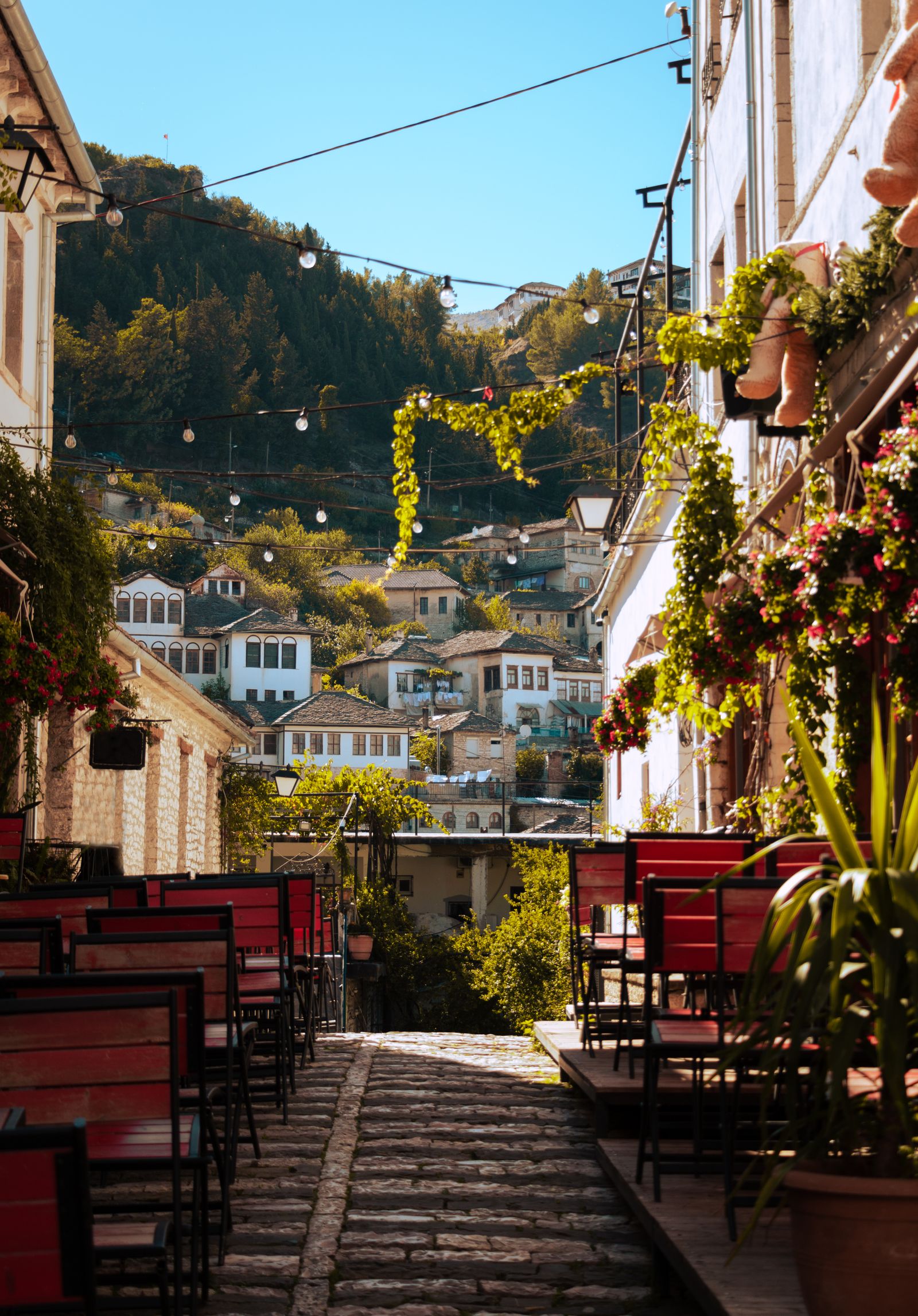 Café tables lining a street in Gjirokastër — the same pavement-café habit you see across Albania, including Tirana