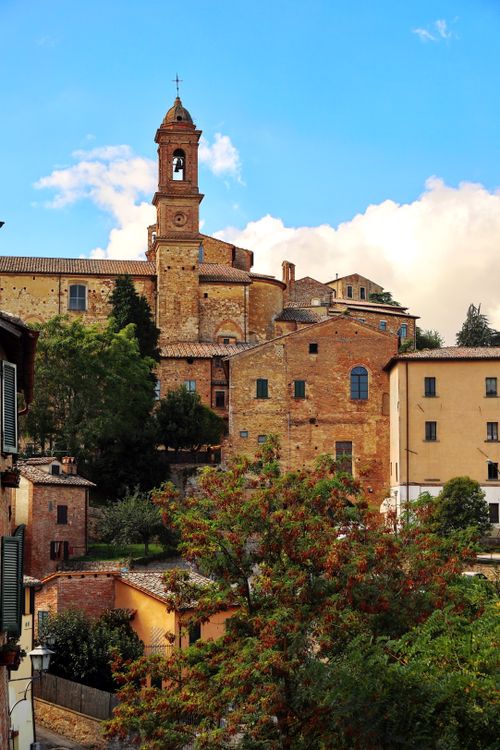 Free Explore the charming architecture of Montepulciano, Tuscany, with timeless stone buildings and lush greenery. Stock Photo