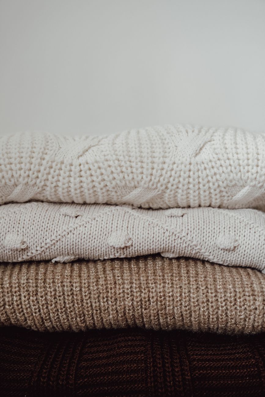 Acid-free tissue paper layered between folded cashmere and wool knit pieces