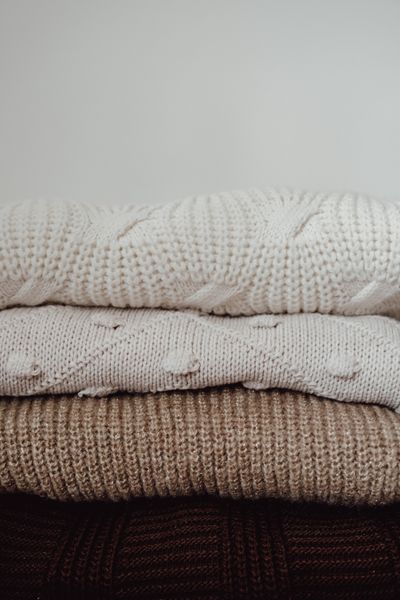 Stack of knitted sweaters in neutral tones — photo by Büşra İnce on Pexels